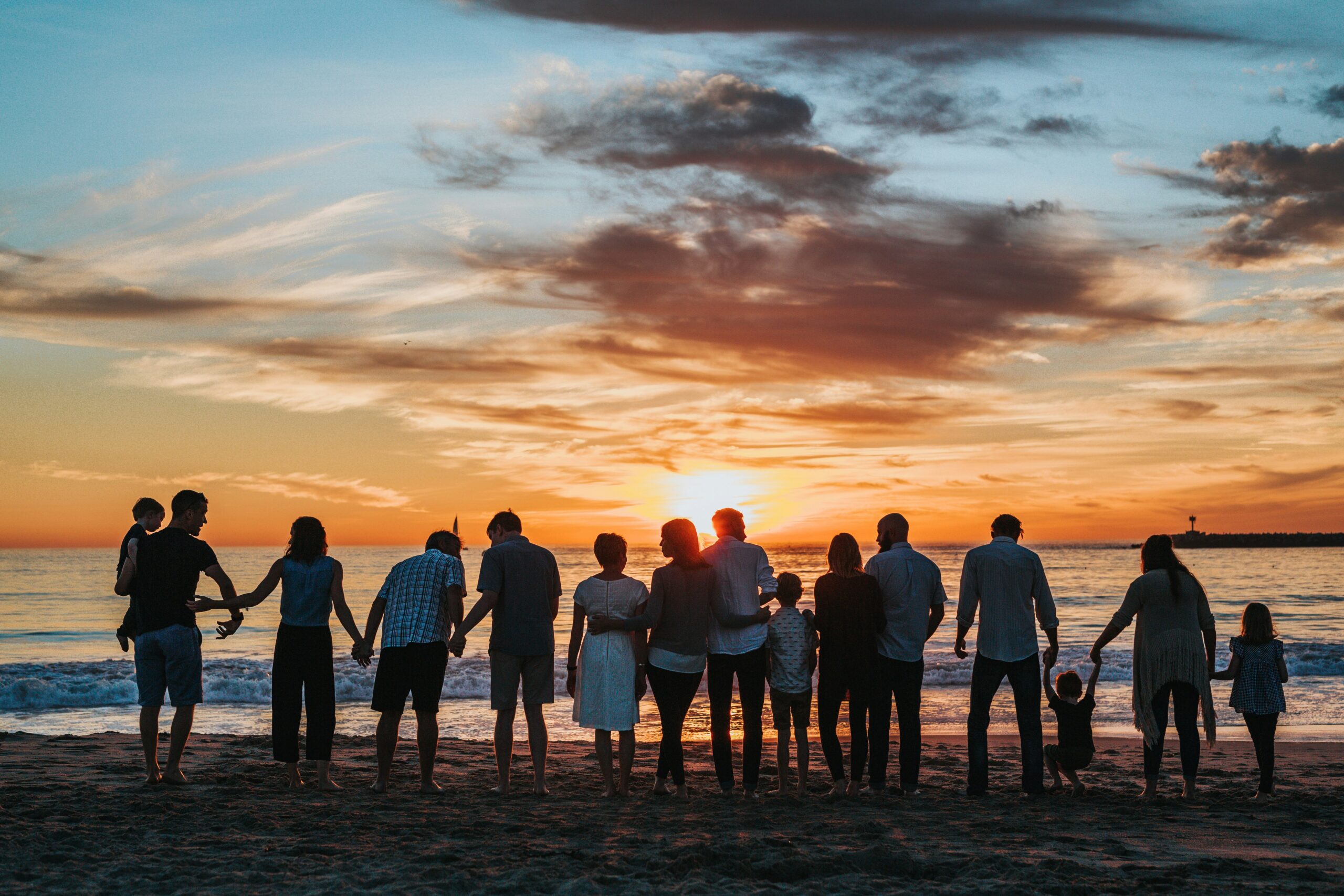 gruppo di persone sulla spiaggia al tramonto