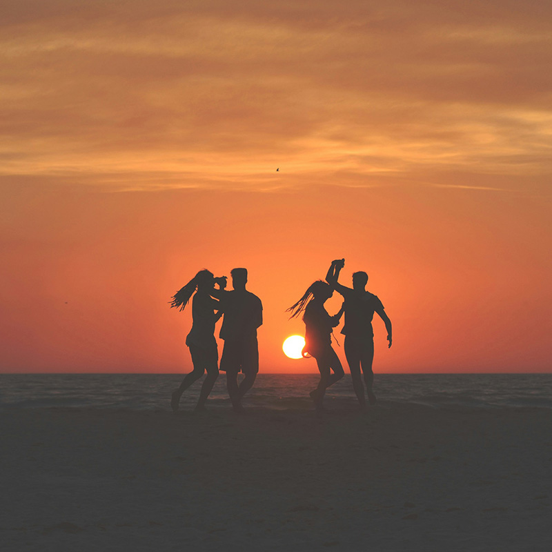 persone sulla spiaggia al tramonto